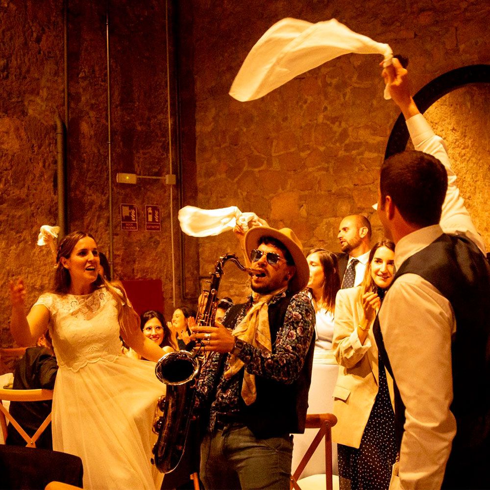 Saxofonista animando a la novia y a los invitados, que agitan servilletas